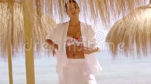 穿比基尼的女人伞下的沙滩上衣视频的预览图
