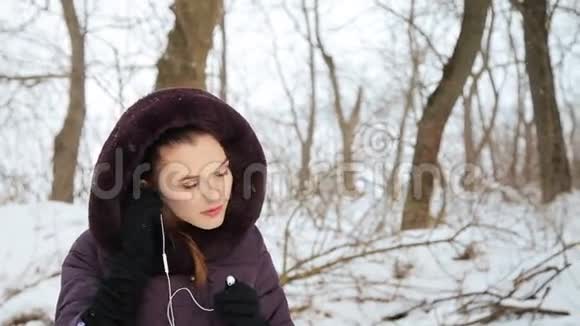 美丽的女孩在冬天听音乐视频的预览图