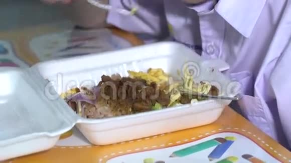穿着学生制服的亚洲孩子在塑料泡沫盒里吃食物视频的预览图