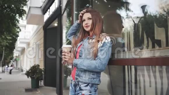 年轻的女人站在咖啡屋前户外活动视频的预览图