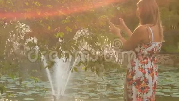 背景灯背面金发女孩照片喷泉后树视频的预览图