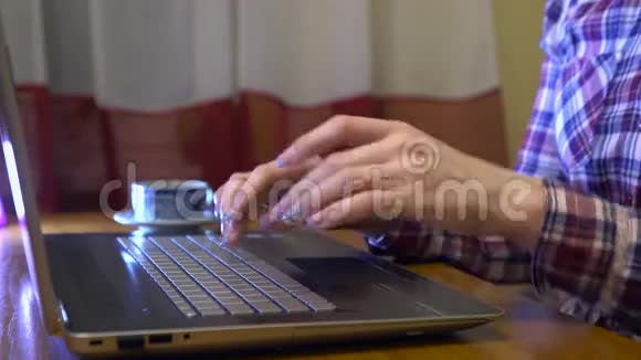 家庭主妇穿着格子衬衫在笔记本电脑上打字视频的预览图
