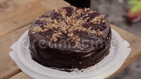 有人在木桌上用刀切巧克力蛋糕视频的预览图