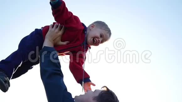 慢动作一个年轻的父亲把他笑的孩子扔到空中户外娱乐视频的预览图