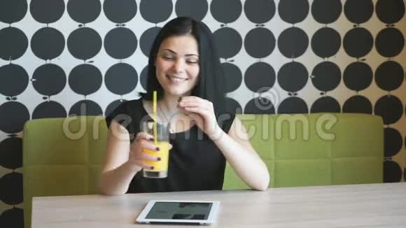 漂亮的女孩在室内喝橙汁视频的预览图