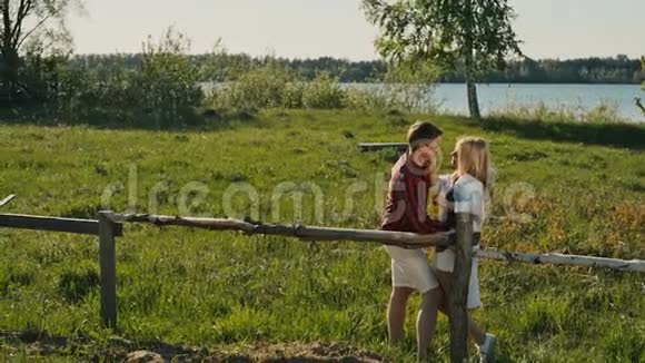 年轻浪漫的情侣站在河岸边视频的预览图
