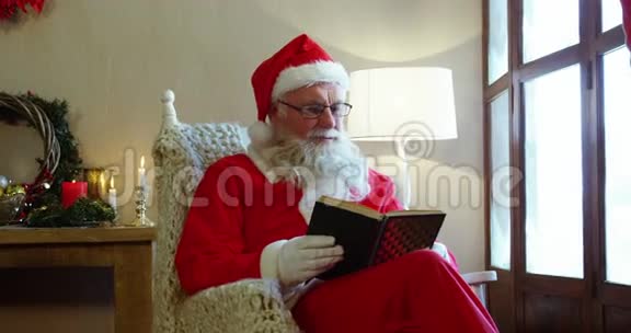 圣诞老人一边看着窗户一边看小说视频的预览图
