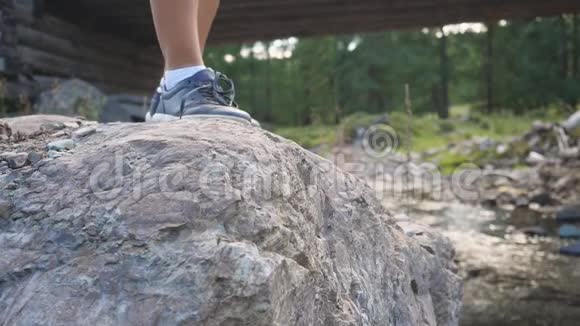 在阳光明媚的夏日里女性徒步旅行者在山景上缓慢地踩着石头视频的预览图