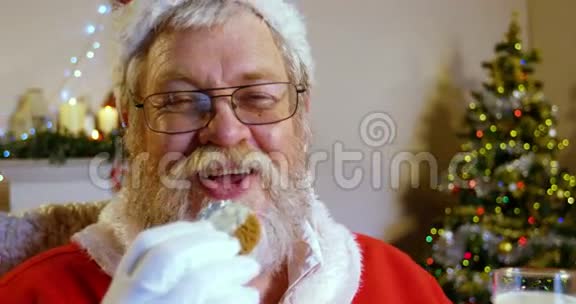 圣诞老人在椅子上放松吃甜食视频的预览图