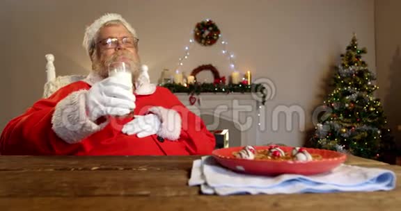 圣诞老人在椅子上放松吃甜食视频的预览图