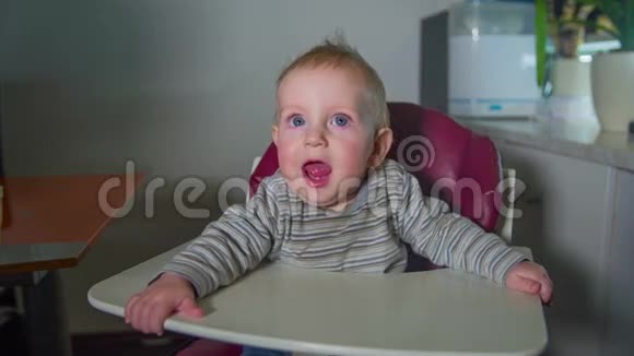 快乐的小孩坐在红色的高椅上视频的预览图