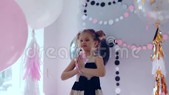 小女孩跳着跳着玩庆祝生日一个孩子的肖像会抛出多种颜色的硬币和纸屑视频的预览图