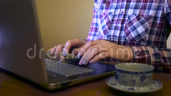 家庭主妇穿着格子衬衫在笔记本电脑上打字视频的预览图