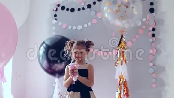 小女孩跳着跳着玩庆祝生日一个孩子的肖像会抛出多种颜色的硬币和纸屑视频的预览图