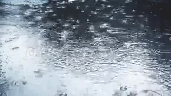 雨水缓慢地落在路面上视频的预览图