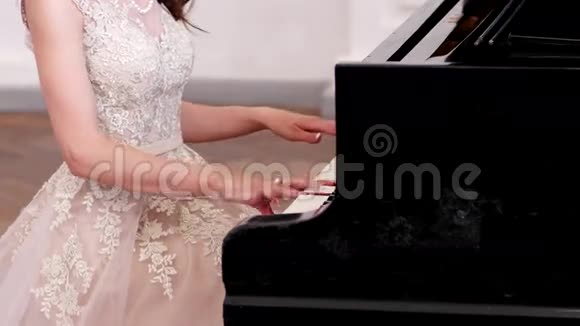 女孩弹钢琴音乐会美丽苗条的身材一个穿着优雅衣服的年轻女人手指触摸着视频的预览图