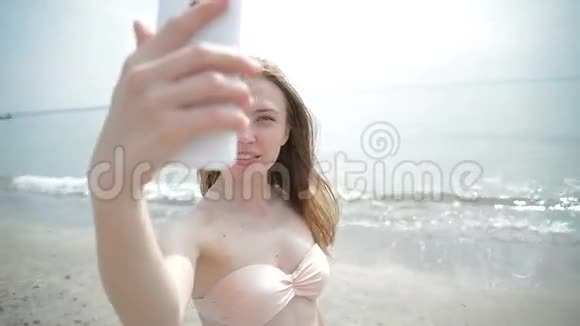 美丽的女人在日落时分用手机自拍视频的预览图
