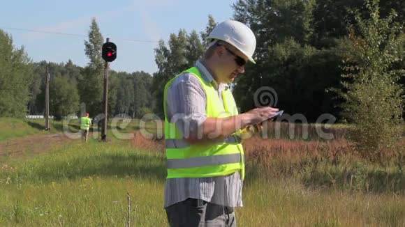 铁路工程师在铁路信号信标附近使用平板电脑视频的预览图