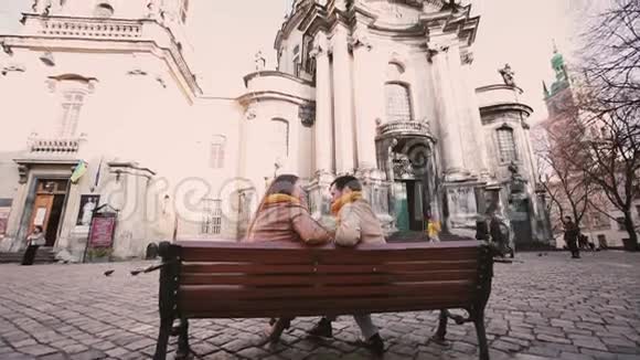 年轻夫妇坐在长凳上在秋城聊天视频的预览图