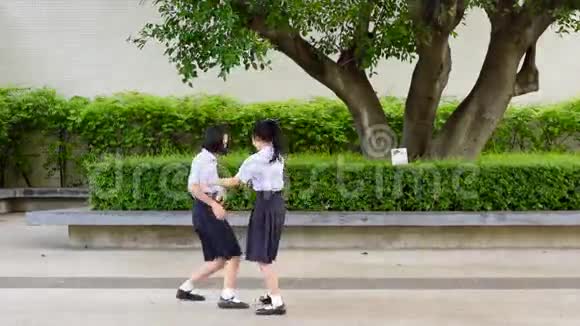 可爱的亚洲泰国高中女学生夫妇穿着校服玩着追逐和捕捉娃娃玩得很开心视频的预览图