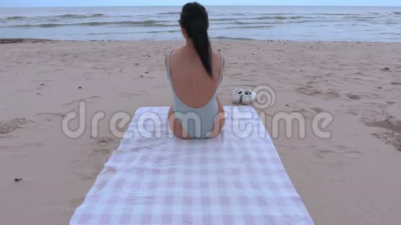 穿泳装的女人睡在海边视频的预览图