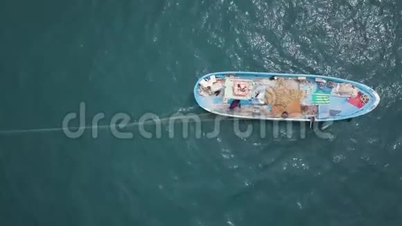 4k由一艘蓝船向海中抛撒渔网的渔民空中视频的预览图