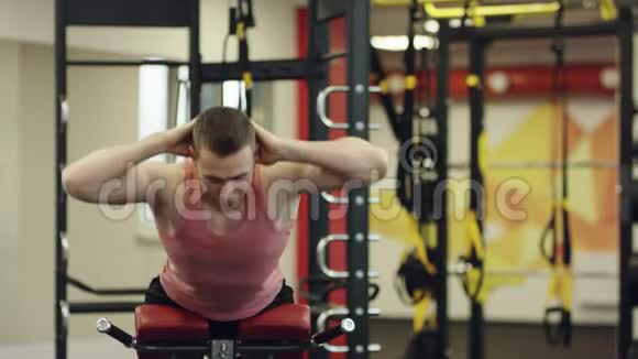 强壮的运动员在健身房的长凳上做健身运动视频的预览图