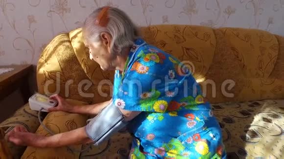 老妇人自己测量血压她坐在他公寓的沙发上安静的晚年视频的预览图