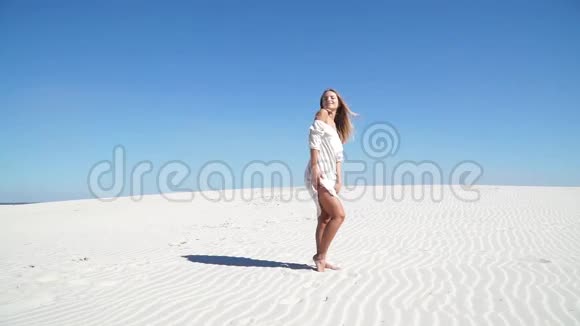 穿着白色裙子站在沙漠里的漂亮女孩视频的预览图