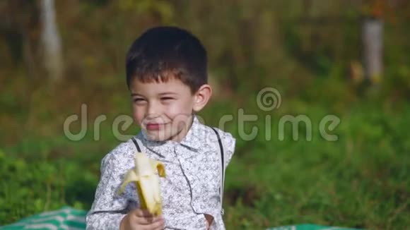 小男孩在花园里吃香蕉视频的预览图