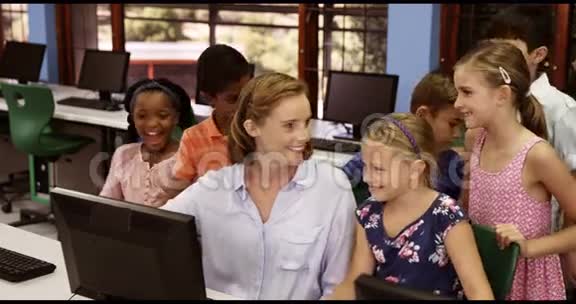教师协助学童在教室使用个人电脑视频的预览图