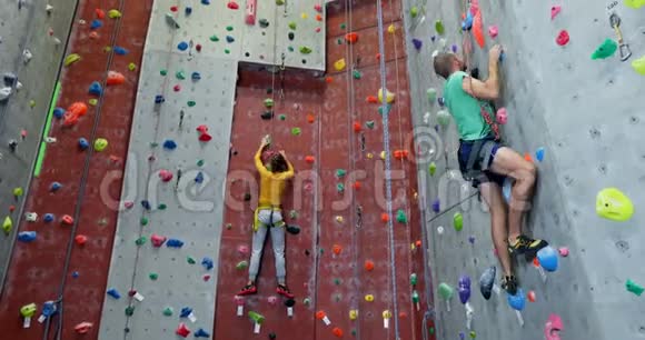 男子和女子在健身室练习攀岩视频的预览图