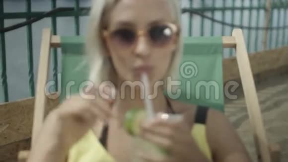 接近一个女人享受热带莫吉托鸡尾酒装饰新鲜水果视频的预览图