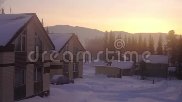 奇妙的冬季景观日落时美丽的冬天景象日出时雪山上的村庄视频的预览图