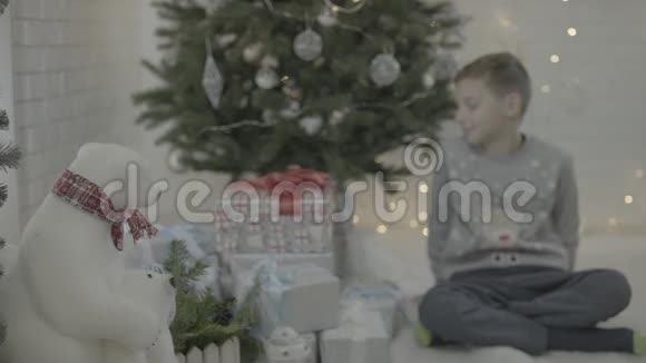 小快乐兴奋的男孩打开圣诞礼物盒装饰新年树节日气氛室视频的预览图