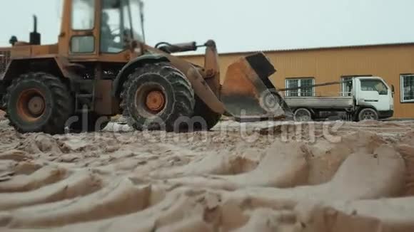 装载机挖掘机在砂场装载翻斗车新厂房视频的预览图