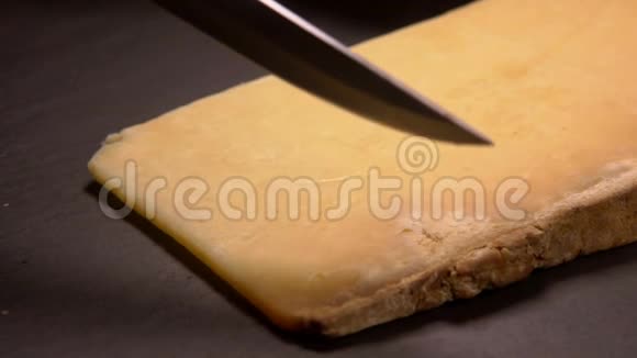 硬的法国奶酪帕尔马干酪切在木板上视频的预览图