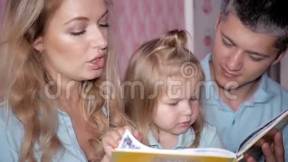 年轻的父母在家给孩子们读这本书母亲父亲和女儿在读书视频的预览图