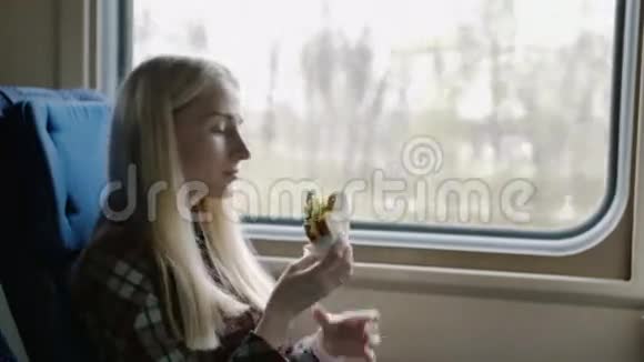 美丽的女人在火车旅行时吃三明治视频的预览图