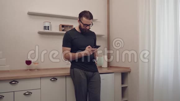 有胡子的男人带着智能手机和一杯茶视频的预览图