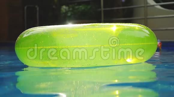 游泳池有一个明亮的黄色充气环缓慢运动并在水面上反射阳光1920x1080视频的预览图