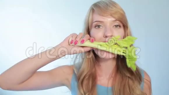 美丽的年轻女人吃一根芹菜视频的预览图