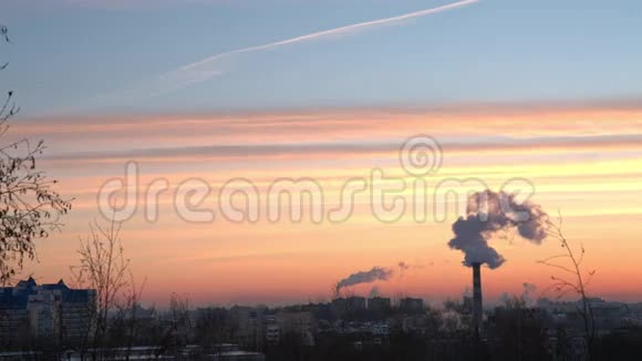 从工厂的烟囱冒出来的烟在城市的黎明前升起视频的预览图
