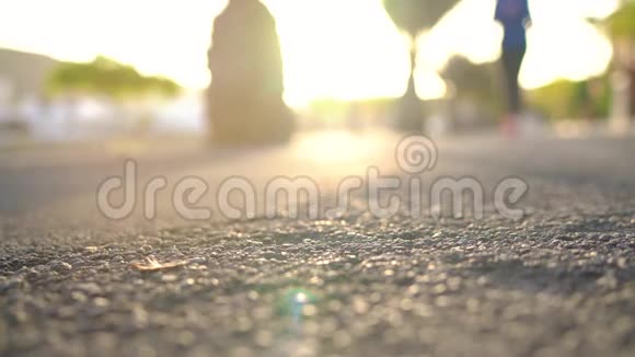 在日落时分女人系鞋带沿着棕榈大道奔跑视频的预览图