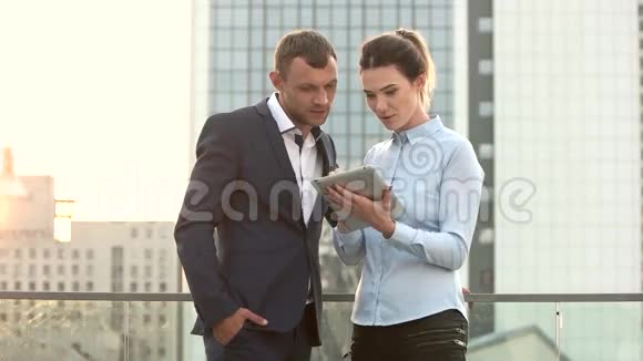 男人和女商人拿着平板电脑视频的预览图