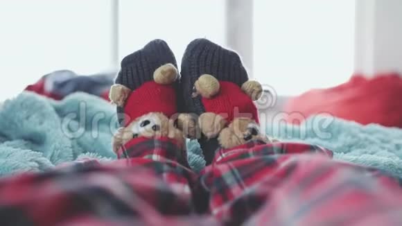 在一个模糊的背景下穿着袜子和可爱的泰迪熊穿着睡衣在床上徒步玩耍视频的预览图