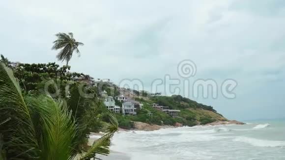 热带海滩在波涛汹涌的大海前的暴风雨中棕榈树挥舞着3840x2160视频的预览图