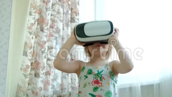小女孩穿着白色衬衫在家看360视频戴着VR耳机视频的预览图