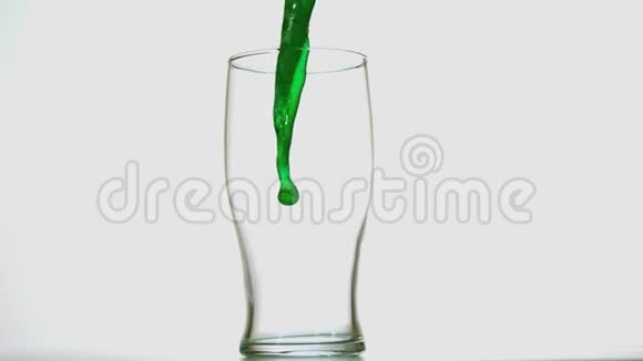 在白色背景下倒入一品脱杯中的绿色啤酒视频的预览图