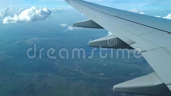 从飞机窗户上看到机翼云层和地面在云层上方飞行视频的预览图